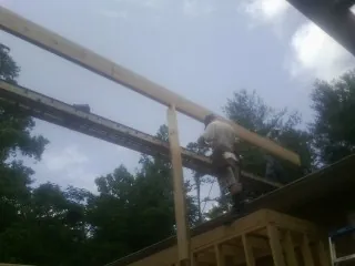 Carpenter setting a ridge beam over a new addition frame — Ice Dam Removal by Roofing Brothers in Sulphur