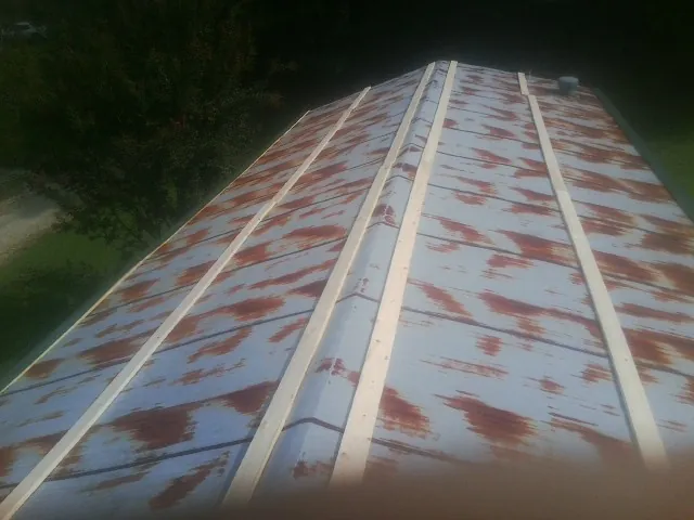 Rusted metal roof panels with new wood purlins before replacement — Storm Damage Roof Repair in Sulphur by Roofing Brothers