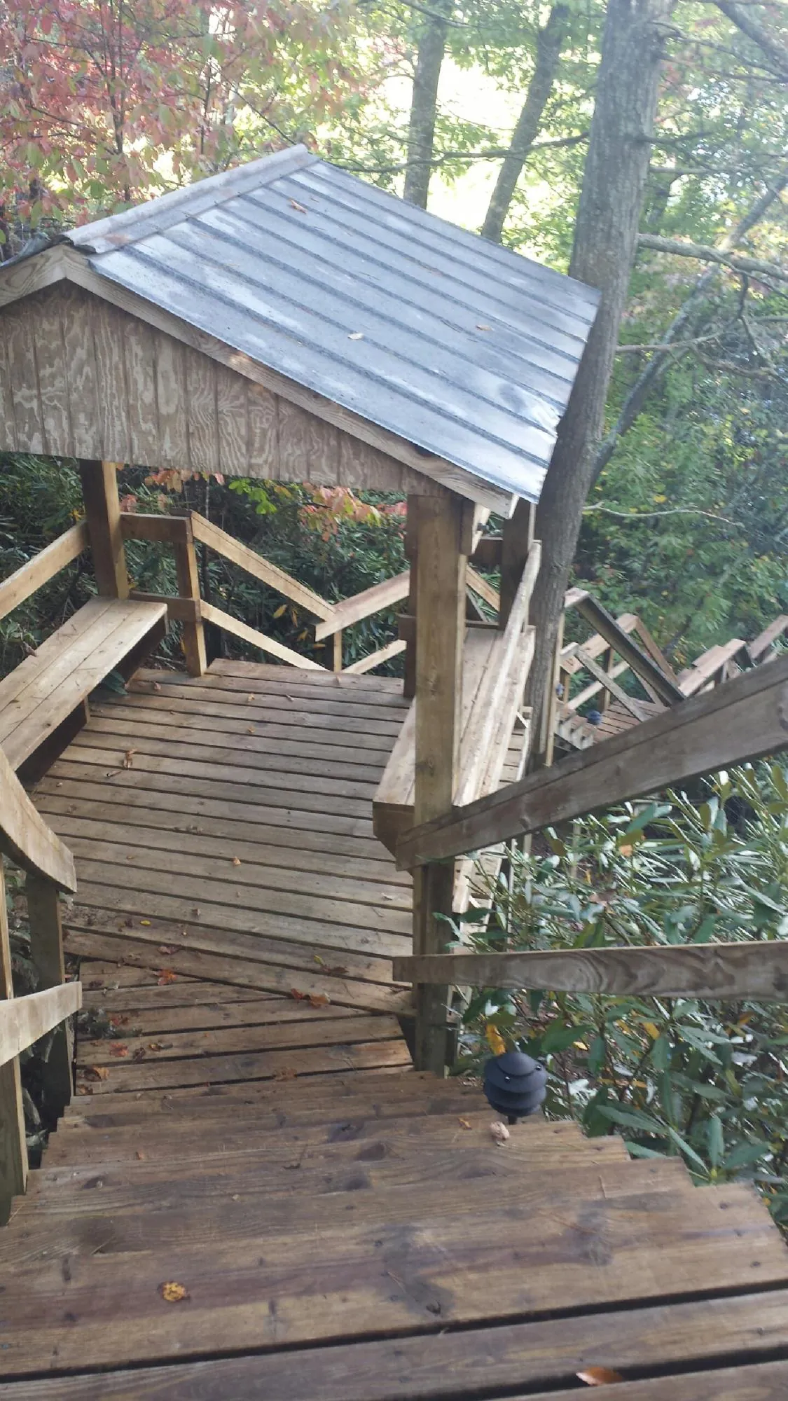 Metal roofed shelter over wooden steps on a wooded walkway — Skylight Repair & Installation work by our crew in Sulphur