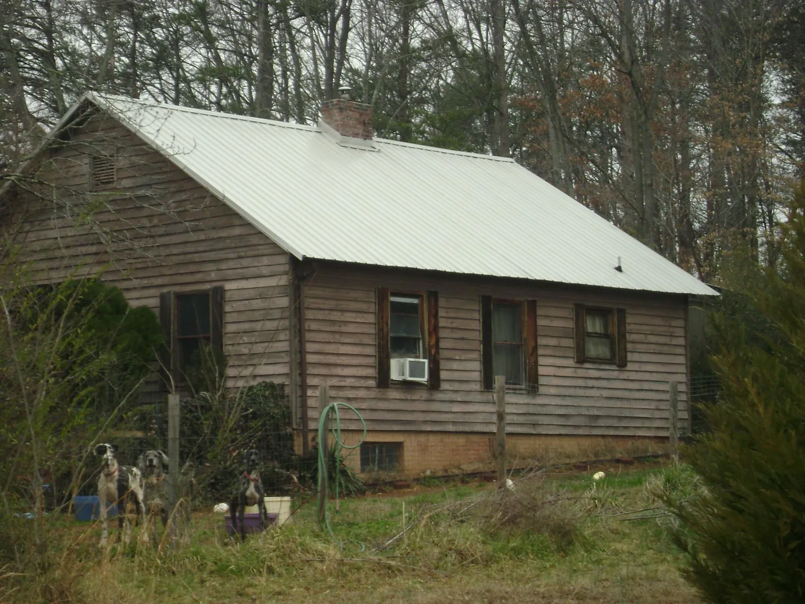 White metal roof on an old wood sided farmhouse, from a Metal Roof Installation job in Sulphur